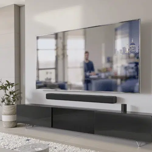 Modern living room with a sleek soundbar below a flat-screen TV in a minimalist home entertainment setup.